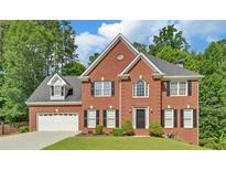 Traditional two-story brick home featuring manicured lawn, black shutters, and attached two-car garage at 1871 Birch Briar Bnd, Lawrenceville, GA 30043