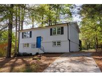 Charming home featuring a bright blue front door and neutral color palette, surrounded by mature trees at 2531 Ridgecrest Nw Dr, Kennesaw, GA 30152