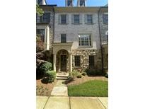 Charming multi-story townhouse featuring a stone and brick facade and well-maintained landscaping at 3676 Brookhaven Manor Ne Xing, Atlanta, GA 30319