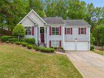 Charming gray split level home with red shutters and well-maintained landscaping at 5525 Tallantworth Trl, Cumming, GA 30040