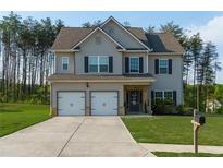 Charming two-story home boasts a well-manicured lawn, two-car garage, and inviting curb appeal at 61 N Village Cir, Rydal, GA 30171