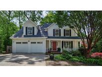 Charming two-story home featuring a well-manicured front yard and a welcoming front porch at 680 Ruxbury Ct, Suwanee, GA 30024