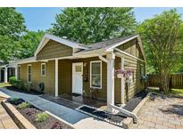Charming home with a well-manicured lawn, complemented by lush greenery and a cozy front porch with colorful flower baskets at 198 Clay Se St # G, Atlanta, GA 30317