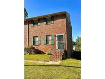 Charming brick townhome featuring well-maintained landscaping and a secure front entrance gate at 6354 Shannon Pkwy # 6F, Union City, GA 30291