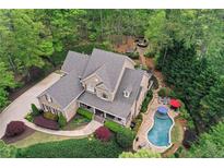 Stunning aerial view of a brick home featuring a private pool, lush landscaping, and a secluded backyard oasis at 176 Nightwind Trce, Acworth, GA 30101