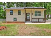 Charming home featuring a welcoming front porch, well-maintained lawn, and neutral exterior at 6454 Boca Grande Blvd, Forest Park, GA 30297