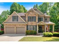 Beautiful stone-and-siding two-story home with manicured lawn, two-car garage, and mature trees at 905 Fox Croft Pl, Canton, GA 30114