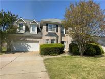 Traditional brick two-story home features a manicured lawn and attached two-car garage at 3835 Portico Run Dr, Buford, GA 30519