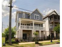 Charming two-story home with a covered front porch and manicured lawn and dark metal fencing at 1432 Fairmont Ave, Atlanta, GA 30318