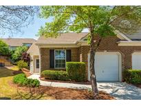 Charming brick home with a well-manicured lawn and attached one car garage at 407 Red Coat Ln, Woodstock, GA 30188