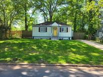 Charming single-story home features a well-manicured lawn and a bright yellow front door at 1294 Almont Sw Dr, Atlanta, GA 30310