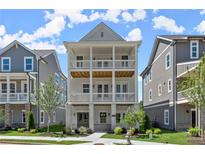Charming three-story home featuring double porches and a landscaped front yard, perfect for outdoor living at 1417 Coretta Scott Bnd, Atlanta, GA 30318