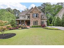 Beautiful stone-accented home featuring a manicured lawn and colorful landscaping at 101 Fernwood Dr, Woodstock, GA 30188
