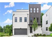 Modern exterior showcasing a two-story home with a painted brick facade, gray accents, and a two-car garage at 1420 Coretta Bend, Atlanta, GA 30318