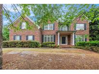 Two-story brick home with dark shutters and a covered front porch framed by white columns at 732 Sweet Gum Way, Canton, GA 30115