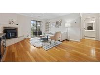 Bright living room with fireplace, wood floors, and sliding doors to a balcony at 970 Sidney Marcus Ne Blvd # 2403, Atlanta, GA 30324