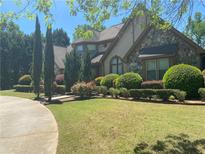 Charming stone and stucco home with lush landscaping and circular driveway on a sunny day at 1173 Jimson Se Cir, Conyers, GA 30013