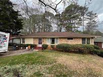 Charming brick home featuring a well-maintained front yard and mature trees at 1782 Mckenzie Dr, Decatur, GA 30032