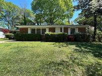 Charming one-story brick home with a green lawn and manicured shrubs in a lush neighborhood at 779 Casplan Sw St, Atlanta, GA 30310