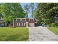 Charming brick home with a well-manicured lawn and long driveway at 2911 Allegro Nw Dr, Atlanta, GA 30318