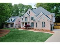 Charming two-story brick home featuring a lush green lawn, mature trees, and inviting curb appeal at 2930 Burnt Hickory Nw Rd, Marietta, GA 30064