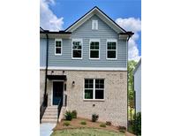 Beautiful townhome featuring a charming brick facade and stylish blue siding at 1230 Ainsworth Aly # 34, Sugar Hill, GA 30518