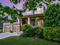 Charming two-story home boasts a well-manicured lawn, attached garages, and inviting front porch with stone accents at 2859 Seagrave Way, Marietta, GA 30066