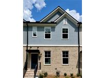 Charming two-story townhome with a brick and shingle exterior, complemented by well-manicured landscaping at 1242 Ainsworth Aly # 40, Sugar Hill, GA 30518
