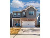Beautiful two-story home with brick accents, gray siding, attached two-car garage, and a well-manicured lawn at 360 Winston Cir, Canton, GA 30114