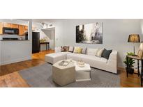 Bright living room features hardwood floors, a modern sofa, and a view of the kitchen with stainless steel appliances at 798 Saint Charles Ne Ave # 7, Atlanta, GA 30306