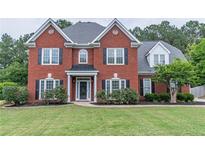 Beautiful two-story red brick home with well-manicured lawn and black shutters at 1004 Spruce Creek Ln, Lawrenceville, GA 30045