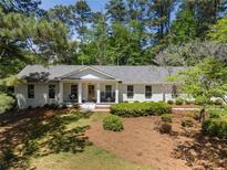 Charming brick home featuring a landscaped front yard and inviting front porch at 250 Hembree Rd, Roswell, GA 30075