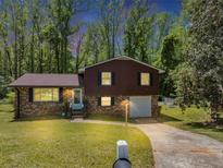 Charming two-story home with brick and brown siding, featuring a well-manicured lawn at 7371 Ovis Ct, Riverdale, GA 30274