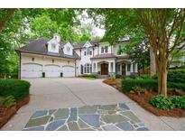 Stunning white brick home featuring a three-car garage and beautifully landscaped front yard at 1412 Lanier Ne Mnr, Atlanta, GA 30319