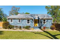 Charming blue single-story home featuring a bright yellow front door and manicured landscaping at 1961 Addison Ne Rd, Marietta, GA 30066