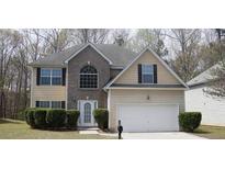 Charming two-story home with a well-manicured lawn, attached two-car garage, and classic architectural details at 2210 Benidorm Ct, South Fulton, GA 30349