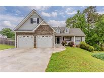 Charming home featuring a two-car garage, stone accents, and a well-maintained front lawn at 51 Legend Creek Way, Douglasville, GA 30134