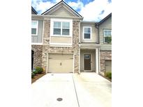 Charming townhome showcasing brick accents, a one-car garage, and a welcoming front entrance at 6318 Scudders Dr, Lithonia, GA 30058