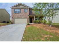 Charming two-story brick home with a well-maintained lawn and an attached two-car garage at 1003 Eldon Ln, Fairburn, GA 30213