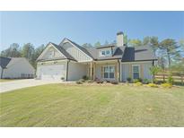 Charming craftsman-style home boasts a manicured lawn, attached two-car garage, and neutral colored exterior at 516 Barnwood Dr, Rockmart, GA 30153