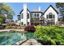 A stunning backyard pool area with lush landscaping and multi-level patio area at 1015 Bedford Gardens Dr, Alpharetta, GA 30022