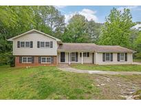 Charming split-level home with a well-manicured lawn and mature trees providing shade at 1008 Hope Springs Ct, Stone Mountain, GA 30083