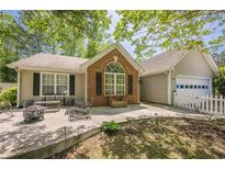 Charming home with a brick accent, fire pit, and patio, perfect for outdoor living and entertaining at 5045 Edinborough Pl, Sugar Hill, GA 30518