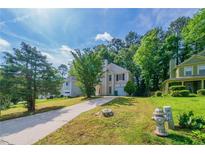 Charming two-story home with landscaped front yard, concrete driveway, and mature trees at 744 Brittany Ct, Stone Mountain, GA 30083