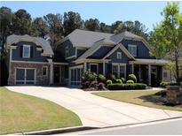 Charming two-story home with a brick facade, attached garage, manicured lawn and extended driveway at 4960 Shade Creek Xing, Cumming, GA 30028