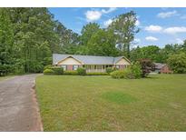 Ranch-style home with large front yard, mature trees, and inviting curb appeal at 5309 Ashley Se Dr, Conyers, GA 30094