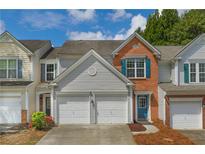 Charming townhome featuring a combination of brick and siding and a two-car garage at 4205 Royal Regency Nw Cir, Kennesaw, GA 30144