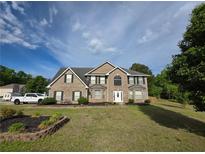 Inviting two-story brick home with manicured lawn and classic architectural details at 6948 Dalehollow Dr, Lithonia, GA 30058