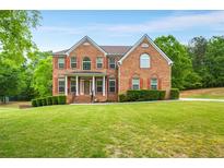Stunning brick home featuring a manicured lawn and lush landscaping at 650 Virginia Highlands, Fayetteville, GA 30215
