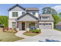 Charming two-story home with a brick and siding exterior, complemented by a well-manicured lawn and inviting front porch at 500 S Hill St, Buford, GA 30518